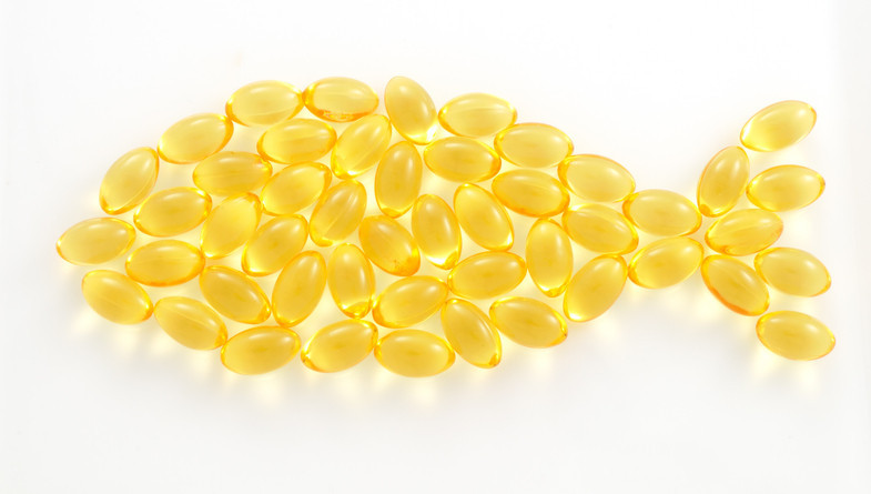 Fish oil capsules organized in the shape of a fish 