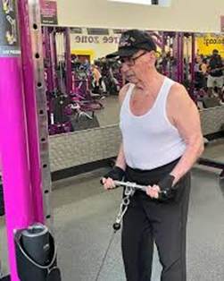 Andrew Bostinto working out in a gym at age 100