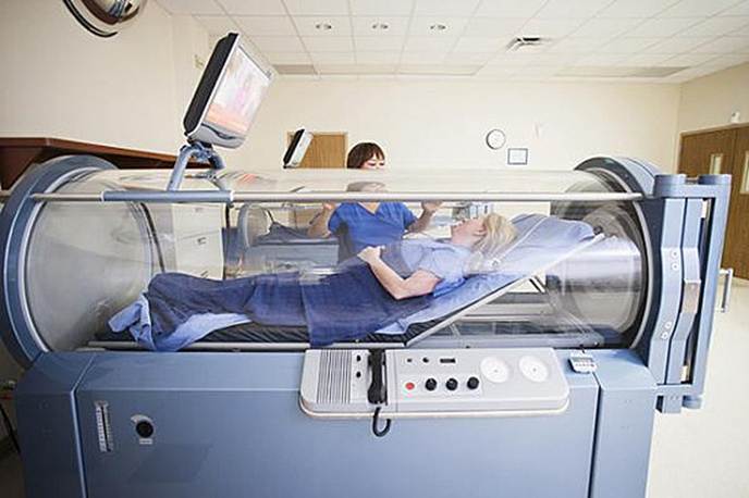 A patient lying in a hyperbaric oxygen chamber